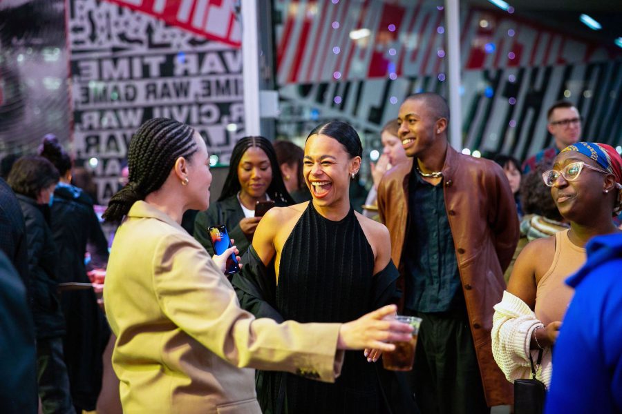 A group of young people of different ethnic backgrounds having fun at a reception.